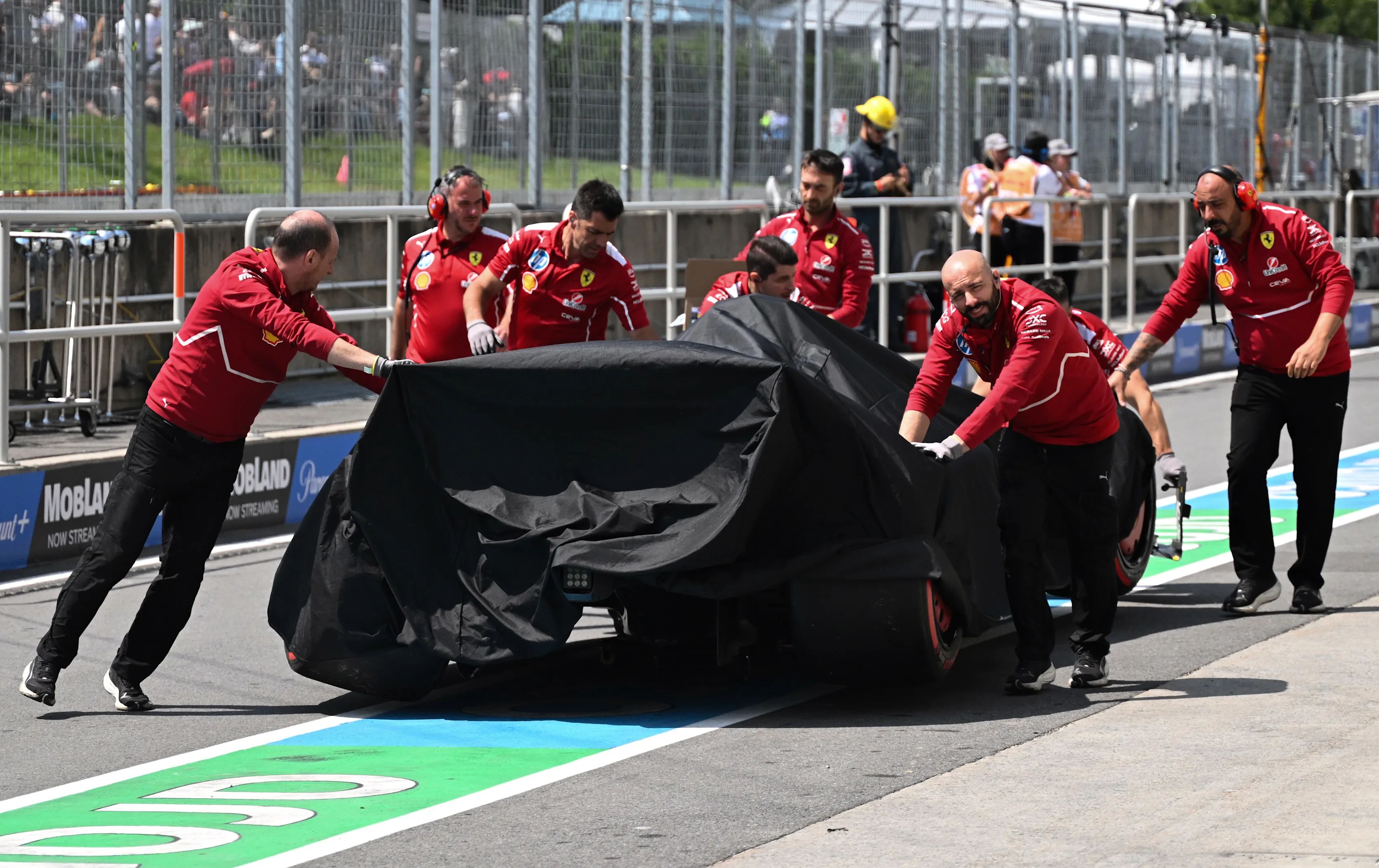 MONTREAL, QUEBEC - JUNE 13: The damaged car of Charles Leclerc of Monaco and Scuderia Ferrari is returned to the garage under a cover during practice ahead of the F1 Grand Prix of Canada at Circuit Gilles-Villeneuve on June 13, 2025 in Montreal, Quebec. (Photo by Mark Sutton - Formula 1/Formula 1 via Getty Images)