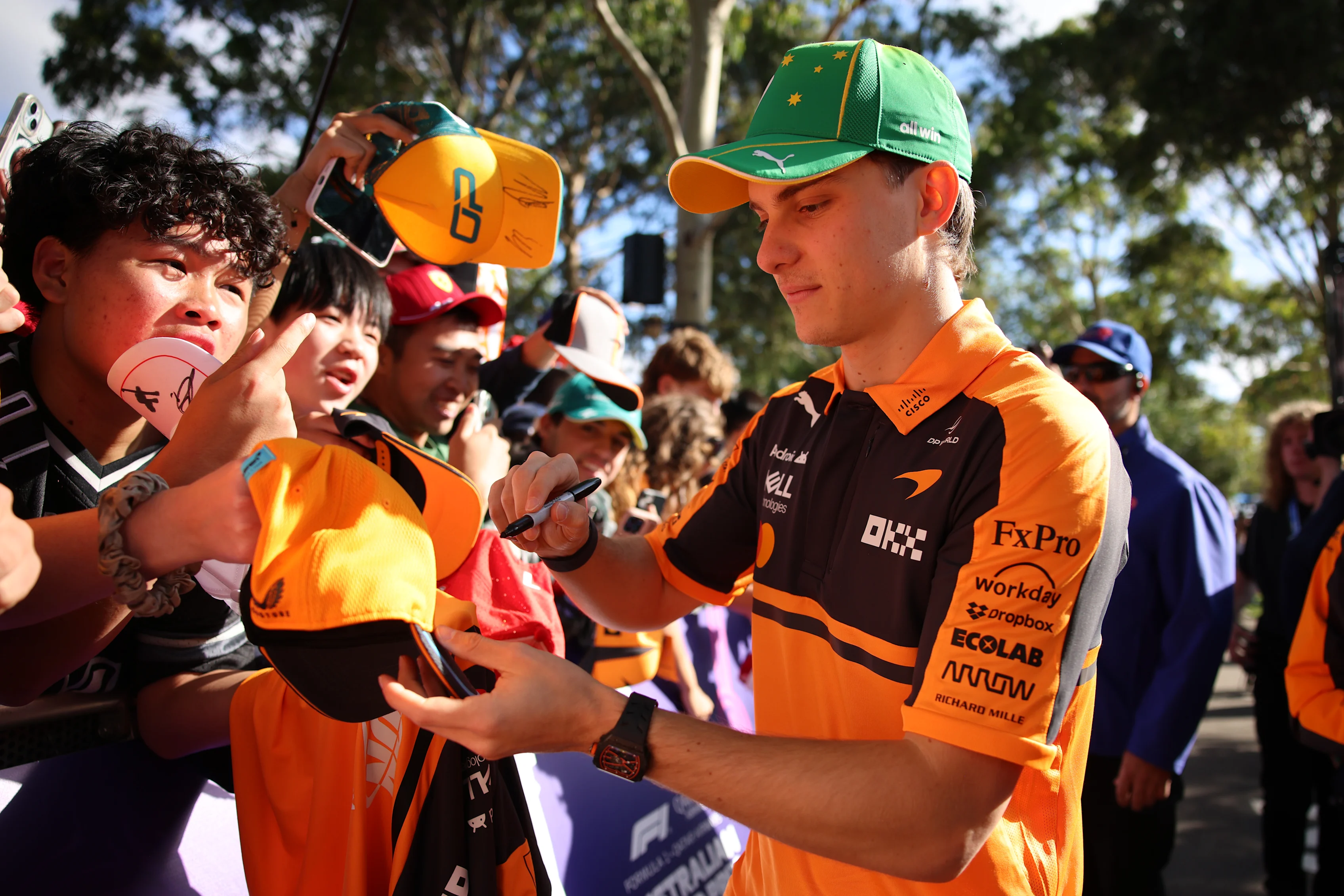 MELBOURNE, AUSTRALIA - MARCH 08: Oscar Piastri of Australia and McLaren signs autographs for fans
