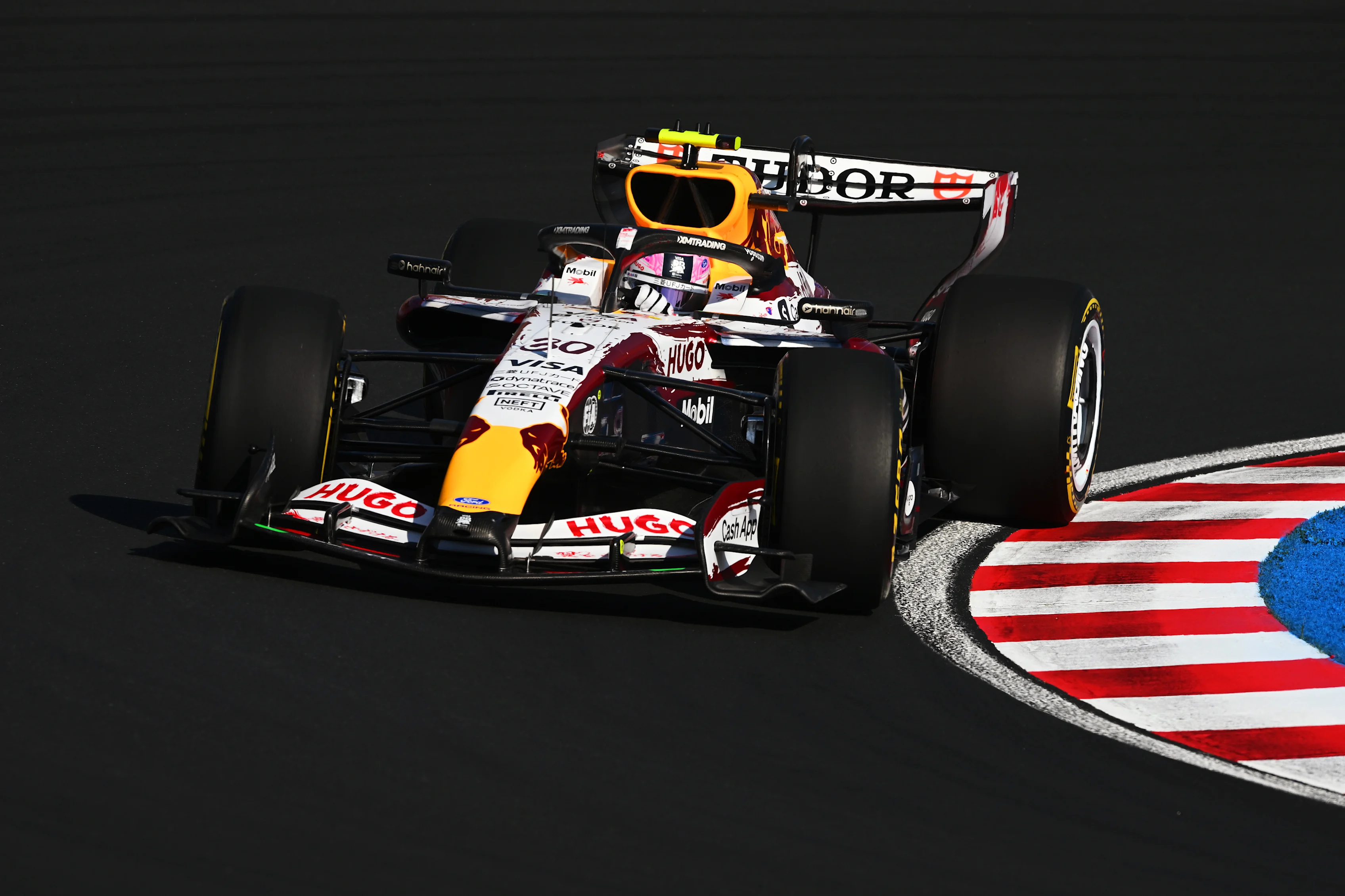 A Visa Cash App Racing Bulls car attacks the kerbs at Suzuka during the 2026 Japanese Grand Prix weekend.