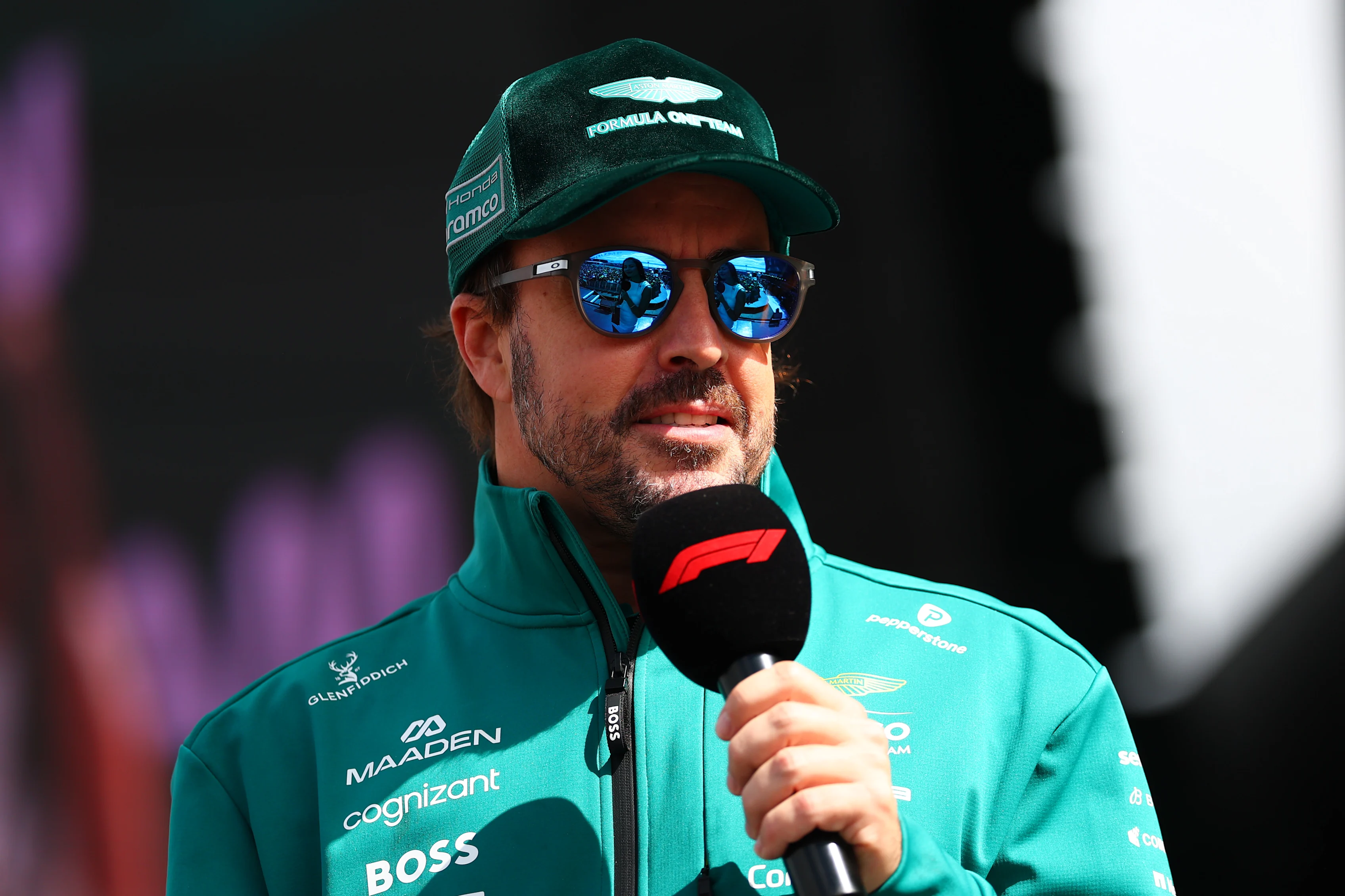 NORTHAMPTON, ENGLAND - JULY 04: Fernando Alonso of Spain and Aston Martin F1 Team talks to the