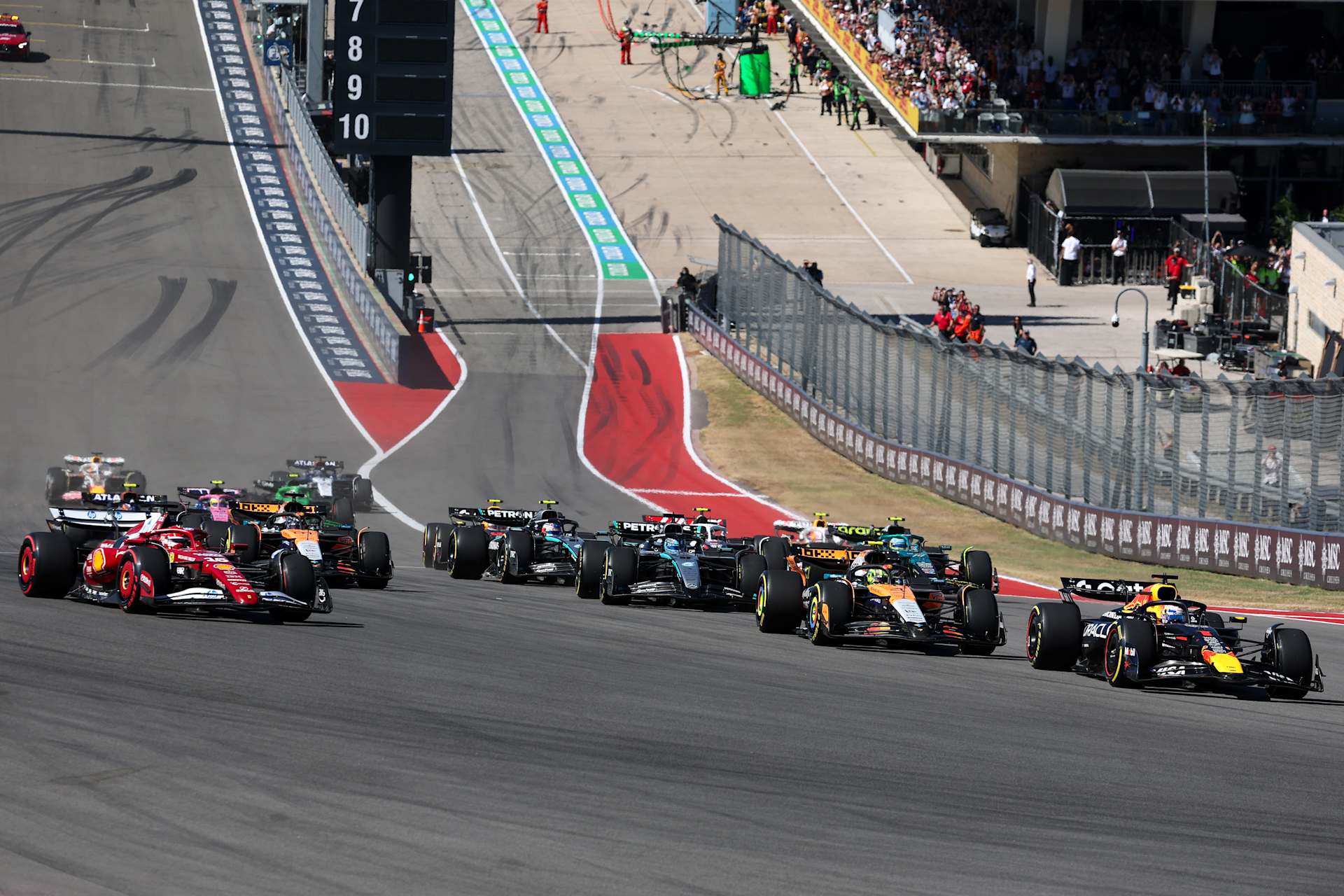 The 2025 F1 field climbing from COTA’s start, with Ferrari and Williams visible on the left.
