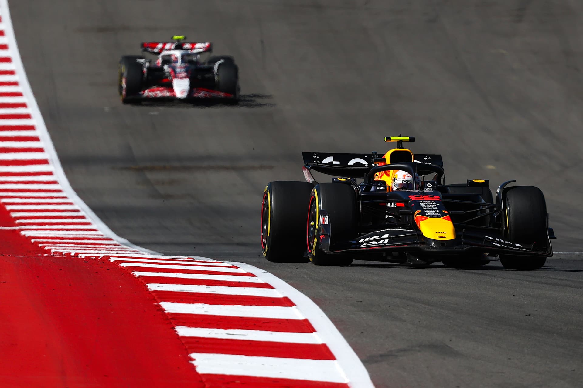 Red Bull number22 leading a Haas along the COTA kerbs in 2025.