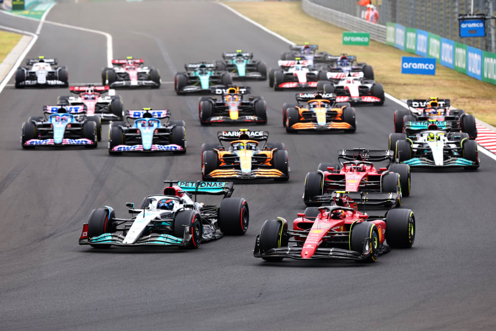 BUDAPEST, HUNGARY - JULY 31: George Russell of Great Britain driving the (63) Mercedes AMG Petronas F1 Team W13 and Carlos Sainz of Spain driving (55) the Ferrari F1-75 battle for track position ahead of the field into turn one at the start during the F1 Grand Prix of Hungary at Hungaroring on July 31, 2022 in Budapest, Hungary. (Photo by Mark Thompson/Getty Images)