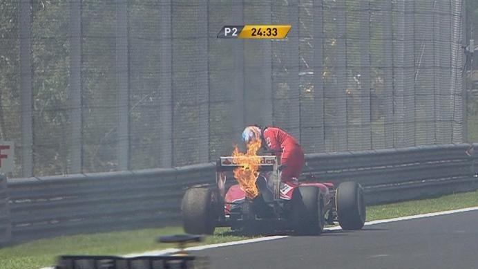 Fernando Alonso calmly exits his Ferrari and then helps to put out the fire at the rear of his F14 T. The session is briefly red flagged while his car is recovered © FOWC Ltd. No reproduction without permission.