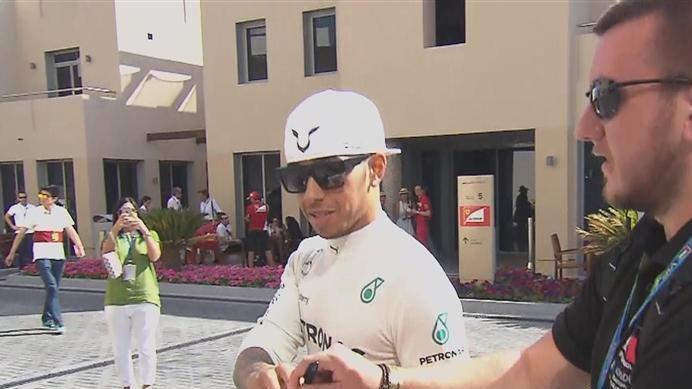 2014 title contender Lewis Hamilton signs an autograph on his way to the Mercedes garage ahead of FP3 © FOWC Ltd. No reproduction without permission.
