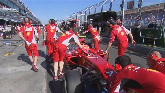 Ferrari's Kimi Raikkonen suffers a minor electronic problem and is led back to the garage by his mechanics © FOWC Ltd. No reproduction without permission.