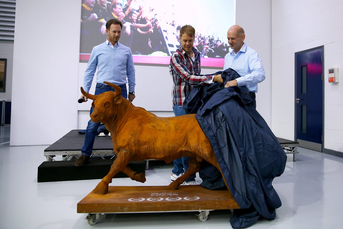 Departing Sebastian Vettel is presented with a bull statue by Red Bull's Christian Horner and Adrian Newey, Milton Keynes, December 2 2014. © Red Bull