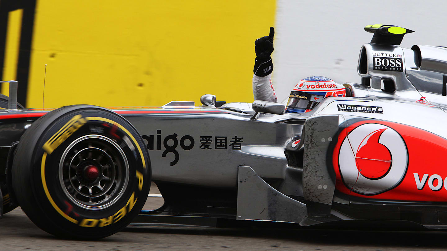 Race winner Jenson Button (GBR) McLaren MP4/26 takes the chequered flag at the finish. Formula One