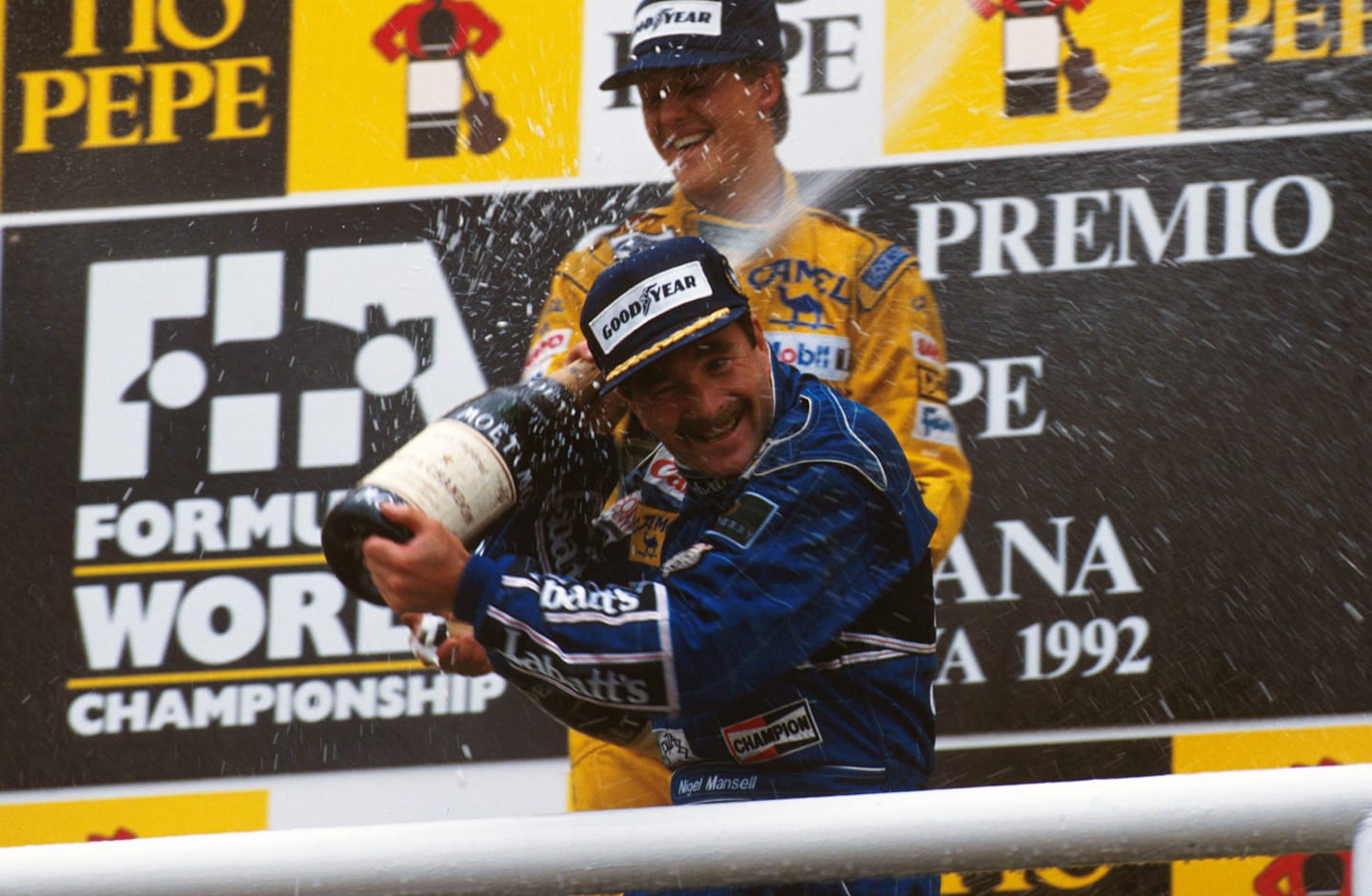 Race winner Nigel Mansell celebrates his victory with Michael Schumacher on the podium.  Spanish