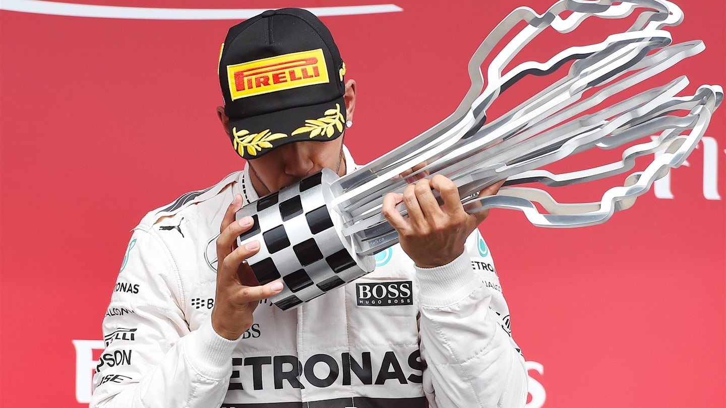 race winner Lewis Hamilton (GBR) Mercedes AMG F1 Celebrates celebrates on the podium with the
