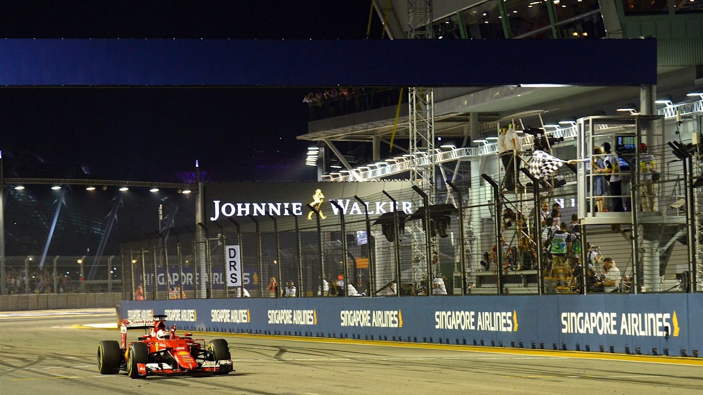 Race winner Sebastian Vettel (GER) Ferrari SF15-T crosses the line and takes the chequered flag at