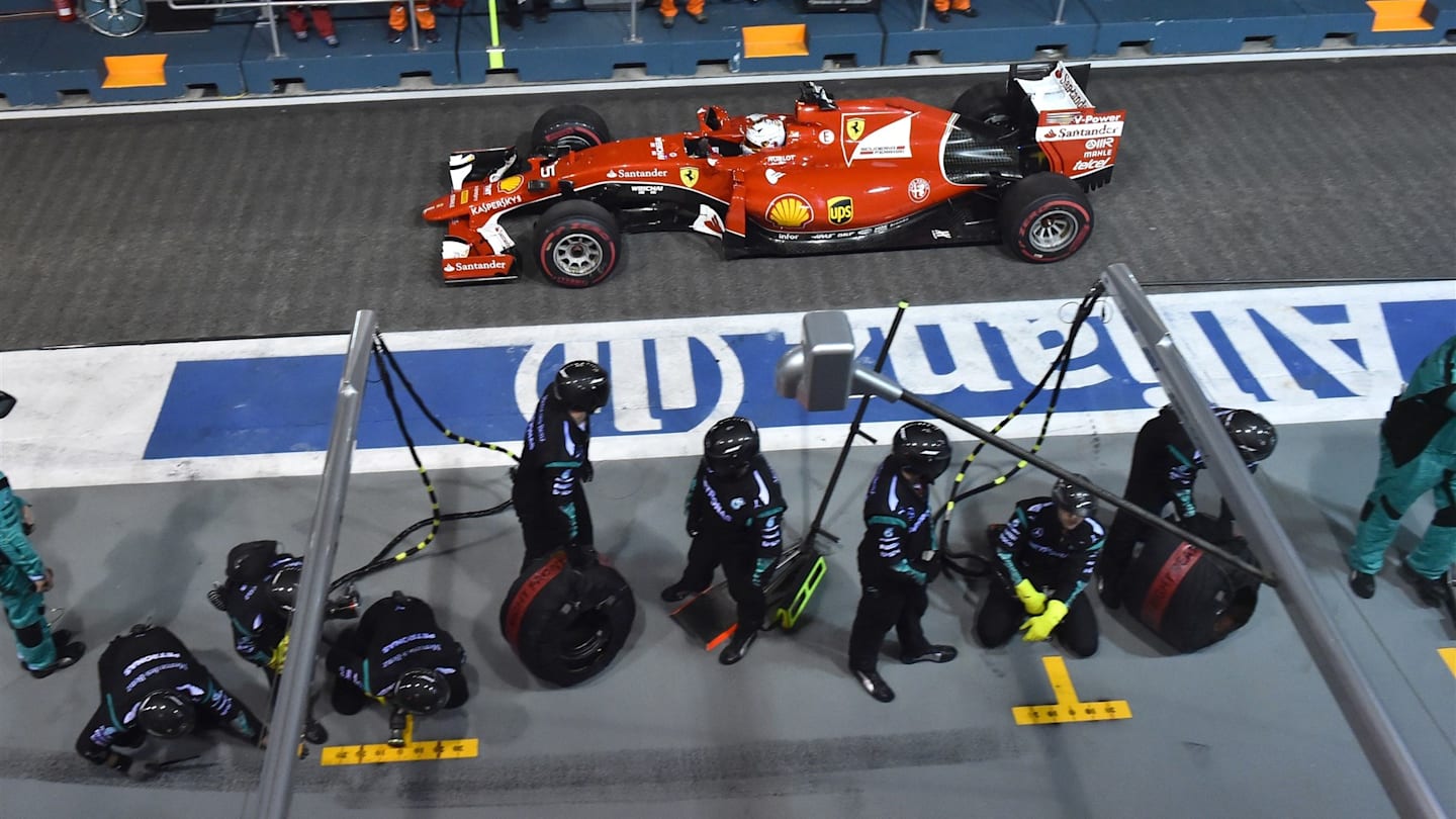 Sebastian Vettel (GER) Ferrari SF15-T passes Mercedes AMG F1 pit crew at Formula One World