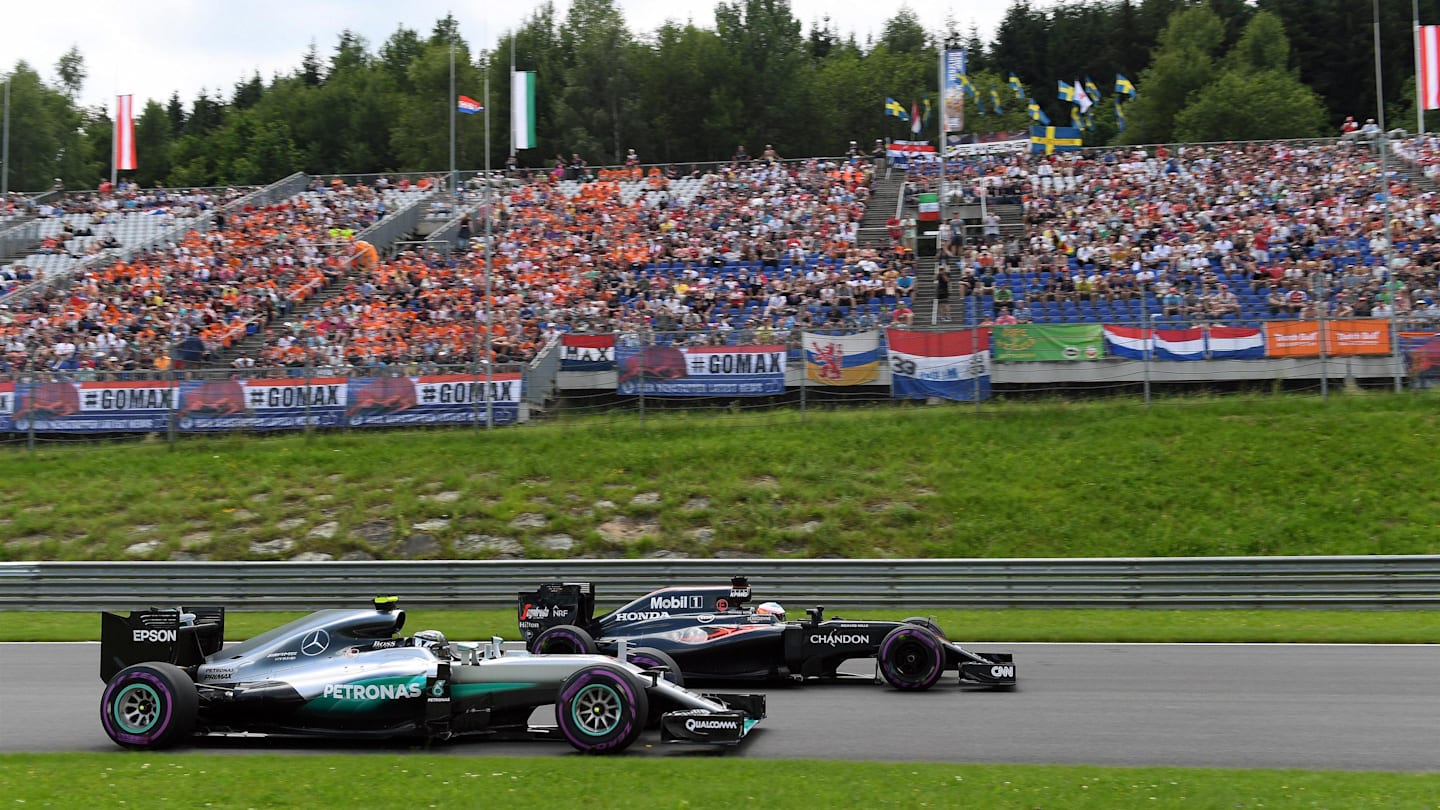 Nico Rosberg (GER) Mercedes-Benz F1 W07 Hybrid and Jenson Button (GBR) McLaren MP4-31 at Formula
