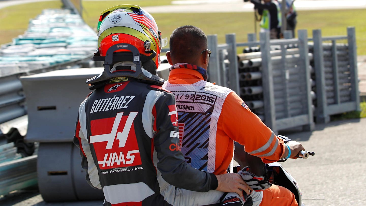 Race retiree Esteban Gutierrez (MEX) Haas F1 gets a ride on a motorbike with a marshal at Formula