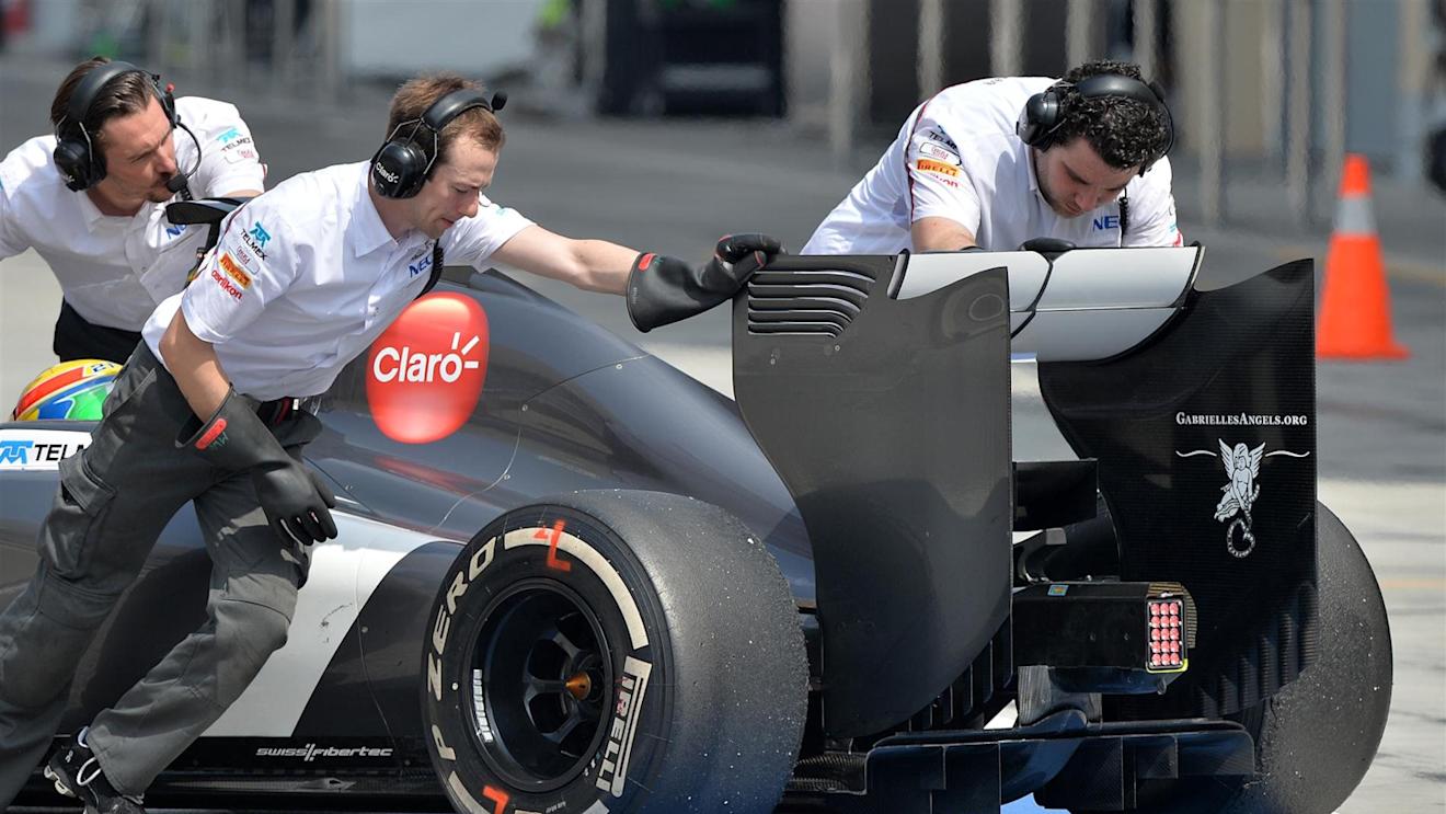 Engineers with protective rubber gloves push the car of Esteban Gutierrez (MEX) Sauber C33 into the garage. Formula One Testing, Day Two, Bahrain International Circuit, Sakhir, Bahrain, Friday, 28 February 2014© Sutton Images. No reproduction without permission