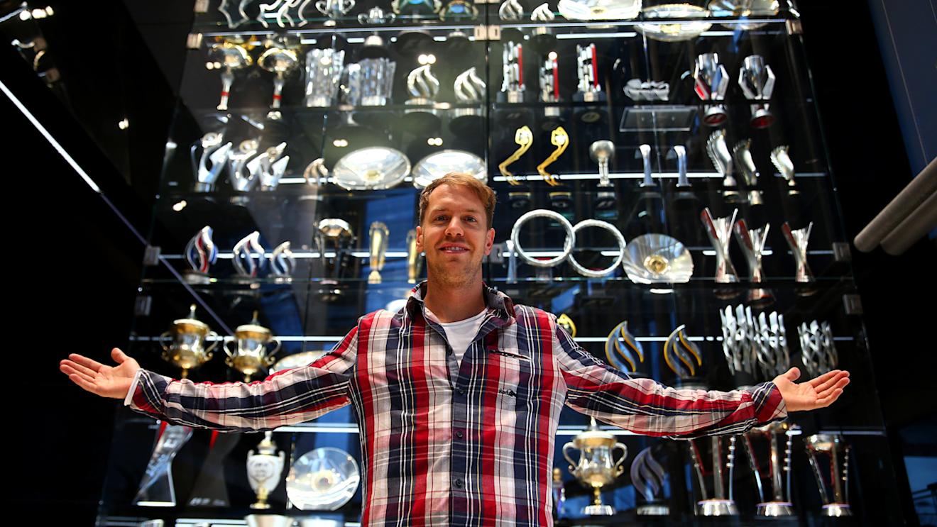 Outgoing Red Bull driver Sebastian Vettel poses with some of the trophies he won, Red Bull factory, Milton Keynes, December 2 2014. © Red Bull