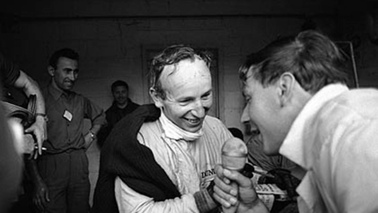 Spa, June 1966: A delighted John Surtees is interviewed following his dominant victory in the Belgian Grand Prix for Ferrari. By the following round he had quit the Italian team and joined Cooper. © Schlegelmilch © No reproduction without permission.