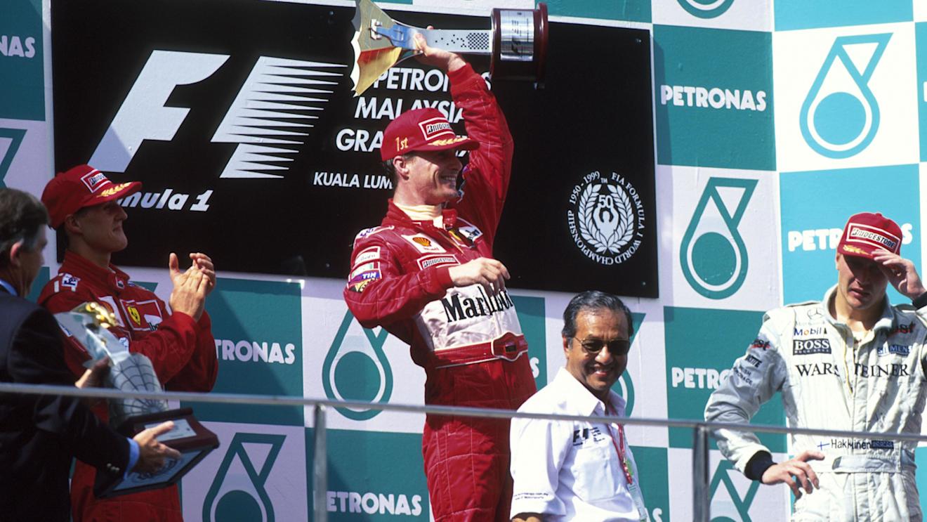 Winner Eddie Irvine celebrates as Schumacher(left) and Hakkinen watch
Malaysian GP, Sepang, 17 October 1999 © ©Sutton Motorsport Images