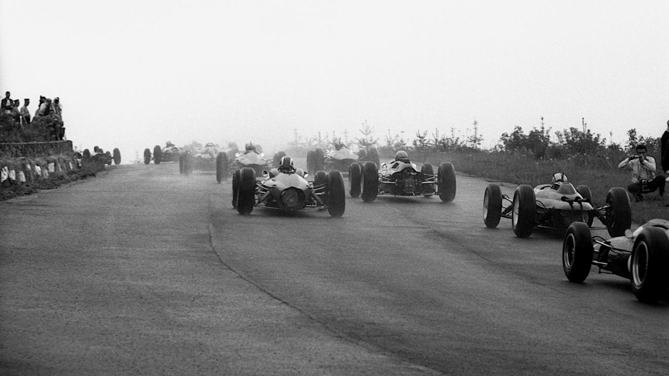 The competitors climb through Eau Rouge in tricky wet conditions at the start; a keen photographer on the right getting very close to the action.
Belgian Grand Prix, Spa-Francorchamps, 9 June 1963.
©Sutton Motorsport Images