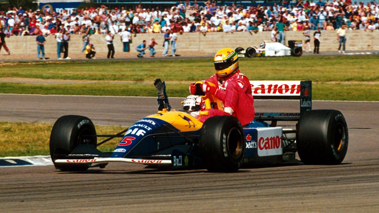 Race winner Nigel Mansell (GBR) Williams FW14 carries back to the pits fourth place finisher Ayrton Senna (BRA) McLaren, who ran out of fuel on the final lap.

British Grand Prix, Silverstone, England, 14 July 1991. © Sutton Motorsport Images