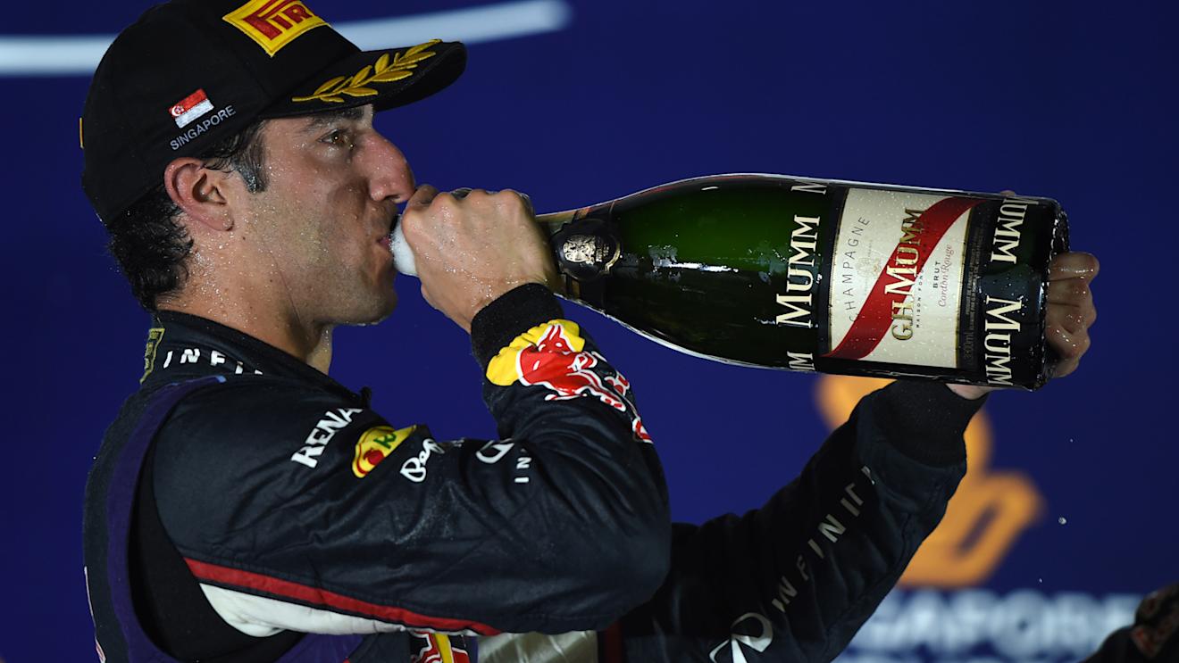 A sweaty Daniel Ricciardo re-hydrates on the podium with the help of some champagne. Singapore 2014. © Sutton Motorsport Images