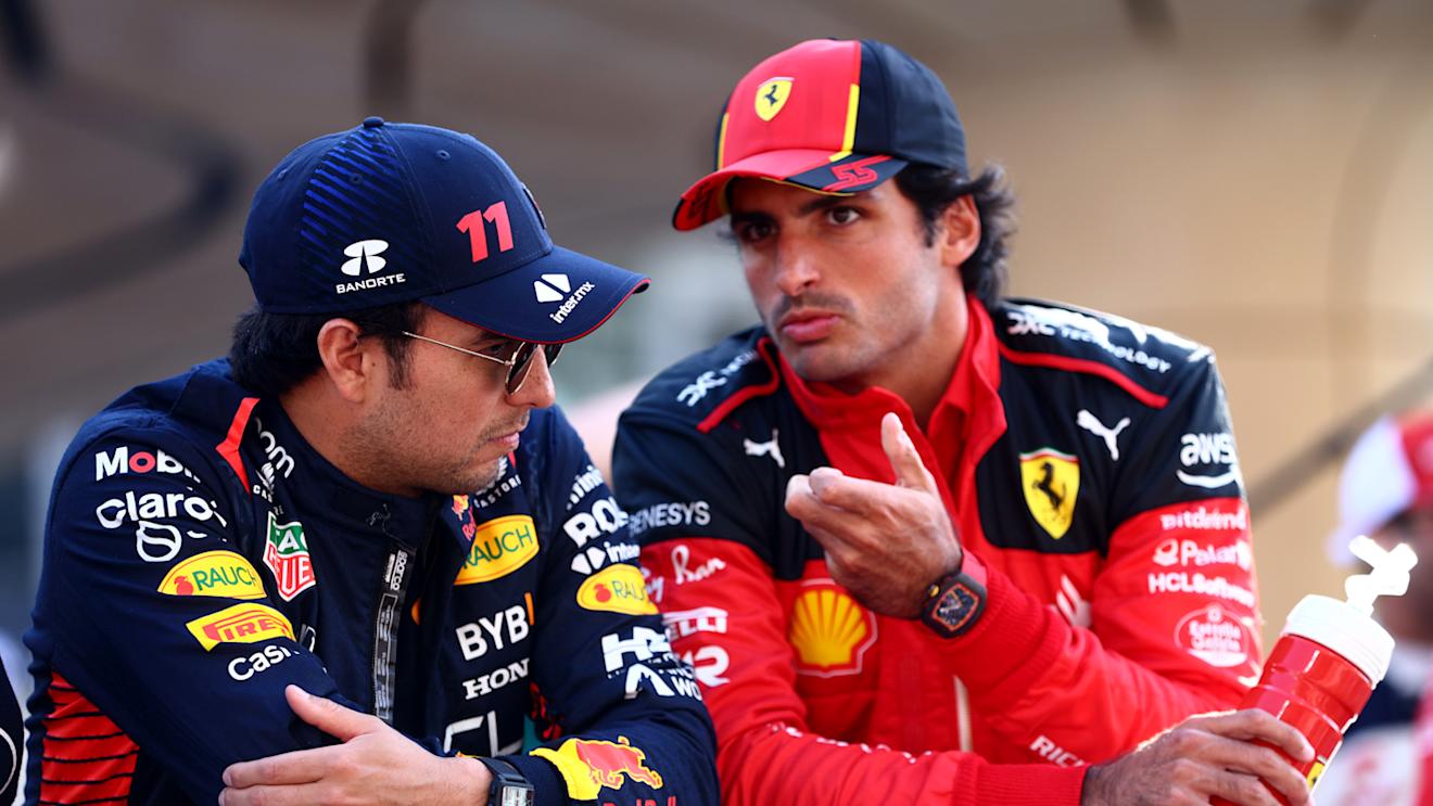 ABU DHABI, UNITED ARAB EMIRATES - NOVEMBER 26: Sergio Perez of Mexico and Oracle Red Bull Racing and Carlos Sainz of Spain and Ferrari talk on the drivers parade prior to the F1 Grand Prix of Abu Dhabi at Yas Marina Circuit on November 26, 2023 in Abu Dhabi, United Arab Emirates. (Photo by Clive Rose/Getty Images)