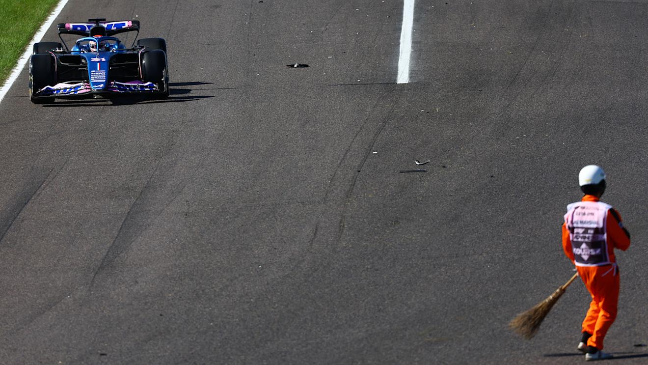 SUZUKA, JAPAN - SEPTEMBER 24: Esteban Ocon of France driving the (31) Alpine F1 A523 Renault on track as a marshal sweeps debris from the track during the F1 Grand Prix of Japan at Suzuka International Racing Course on September 24, 2023 in Suzuka, Japan. (Photo by Mark Thompson/Getty Images)