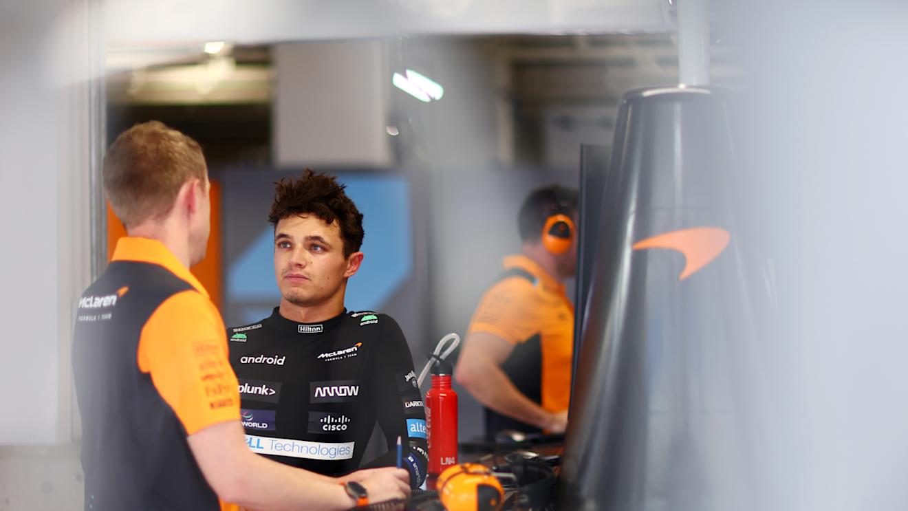 SUZUKA, JAPAN - SEPTEMBER 22: Lando Norris of Great Britain and McLaren talks with a McLaren team member in the garage during practice ahead of the F1 Grand Prix of Japan at Suzuka International Racing Course on September 22, 2023 in Suzuka, Japan. (Photo by Dan Istitene - Formula 1/Formula 1 via Getty Images)