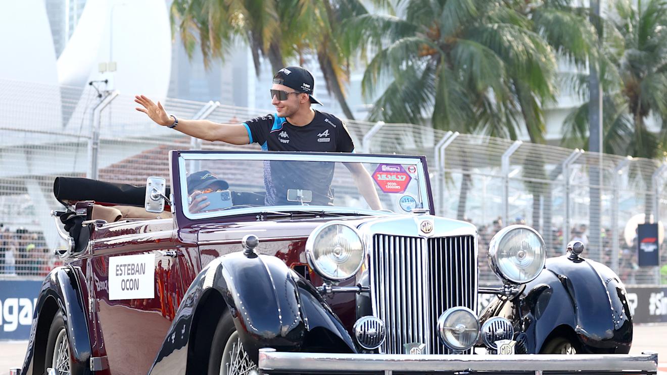 SINGAPORE, SINGAPORE - SEPTEMBER 17: Esteban Ocon of France and Alpine F1 waves to the crowd on the drivers parade prior to the F1 Grand Prix of Singapore at Marina Bay Street Circuit on September 17, 2023 in Singapore, Singapore. (Photo by Mark Thompson/Getty Images)