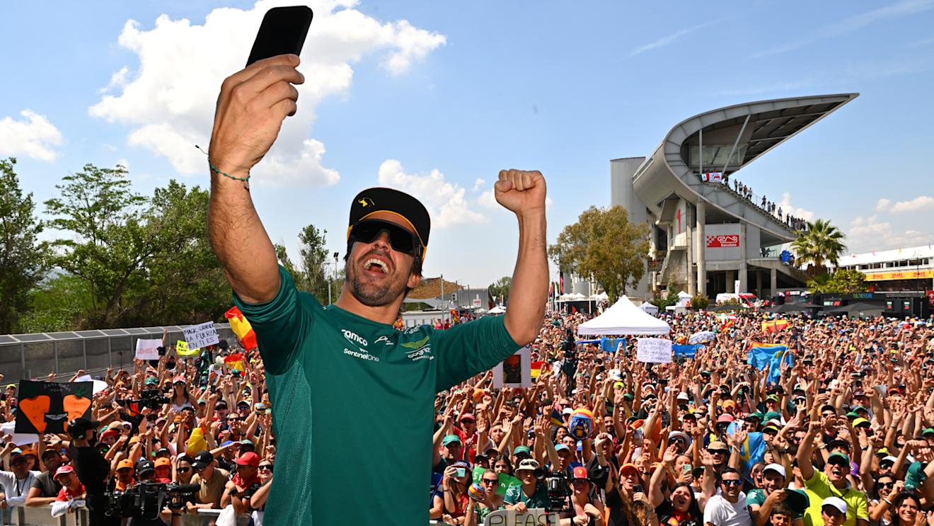 BARCELONA, SPAIN - JUNE 02: Fernando Alonso of Spain and Aston Martin F1 Team takes a photo from the fan stage prior to practice ahead of the F1 Grand Prix of Spain at Circuit de Barcelona-Catalunya on June 02, 2023 in Barcelona, Spain. (Photo by Dan Mullan - Formula 1/Formula 1 via Getty Images)