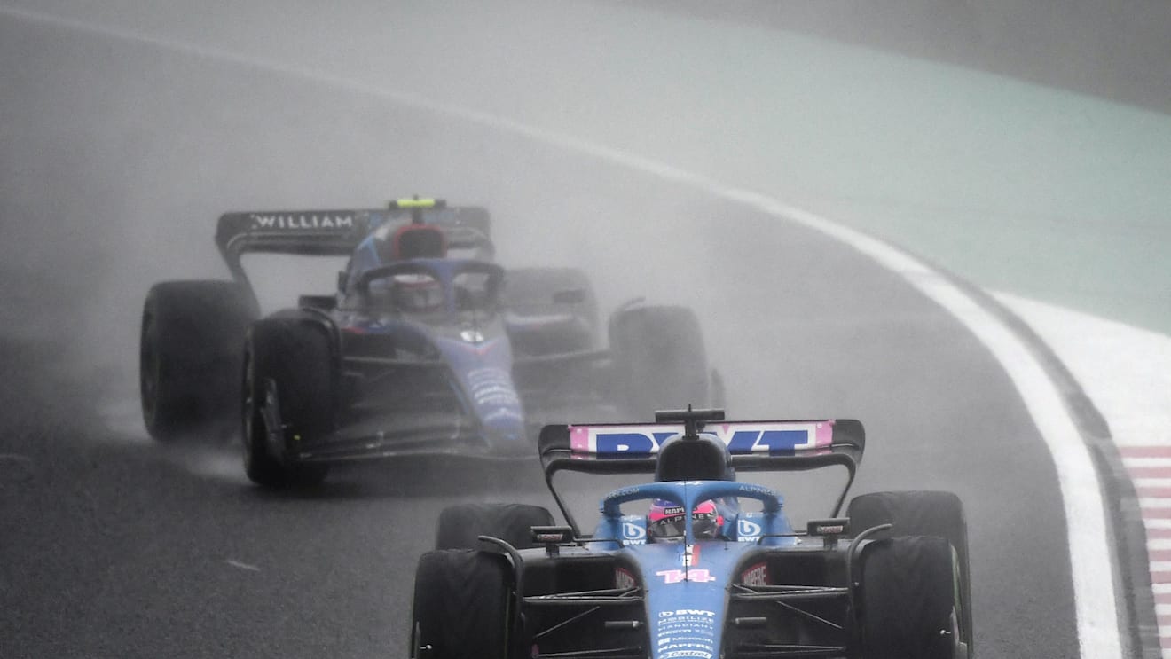Alpine's Spanish driver Fernando Alonso (C) drives in front of Williams' Canadian driver Nicholas Latifi during the Formula One Japanese Grand Prix at Suzuka, Mie prefecture on October 9, 2022. (Photo by Toshifumi KITAMURA / AFP) (Photo by TOSHIFUMI KITAMURA/AFP via Getty Images)