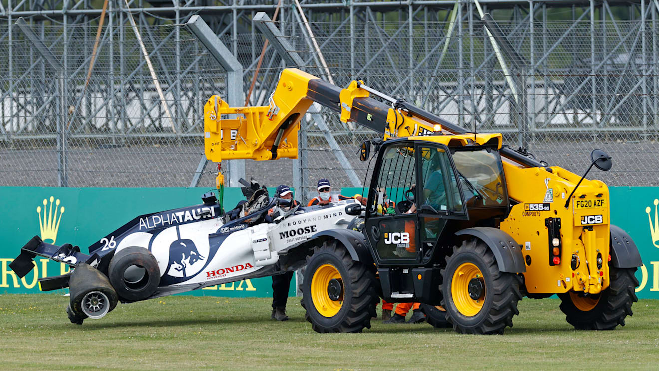 Marshals in face coverings take away the car of AlphaTauri's Russian driver Daniil Kvyat after a crash during the Formula One British Grand Prix at the Silverstone motor racing circuit in Silverstone, central England on August 2, 2020. (Photo by ANDREW BOYERS / POOL / AFP)