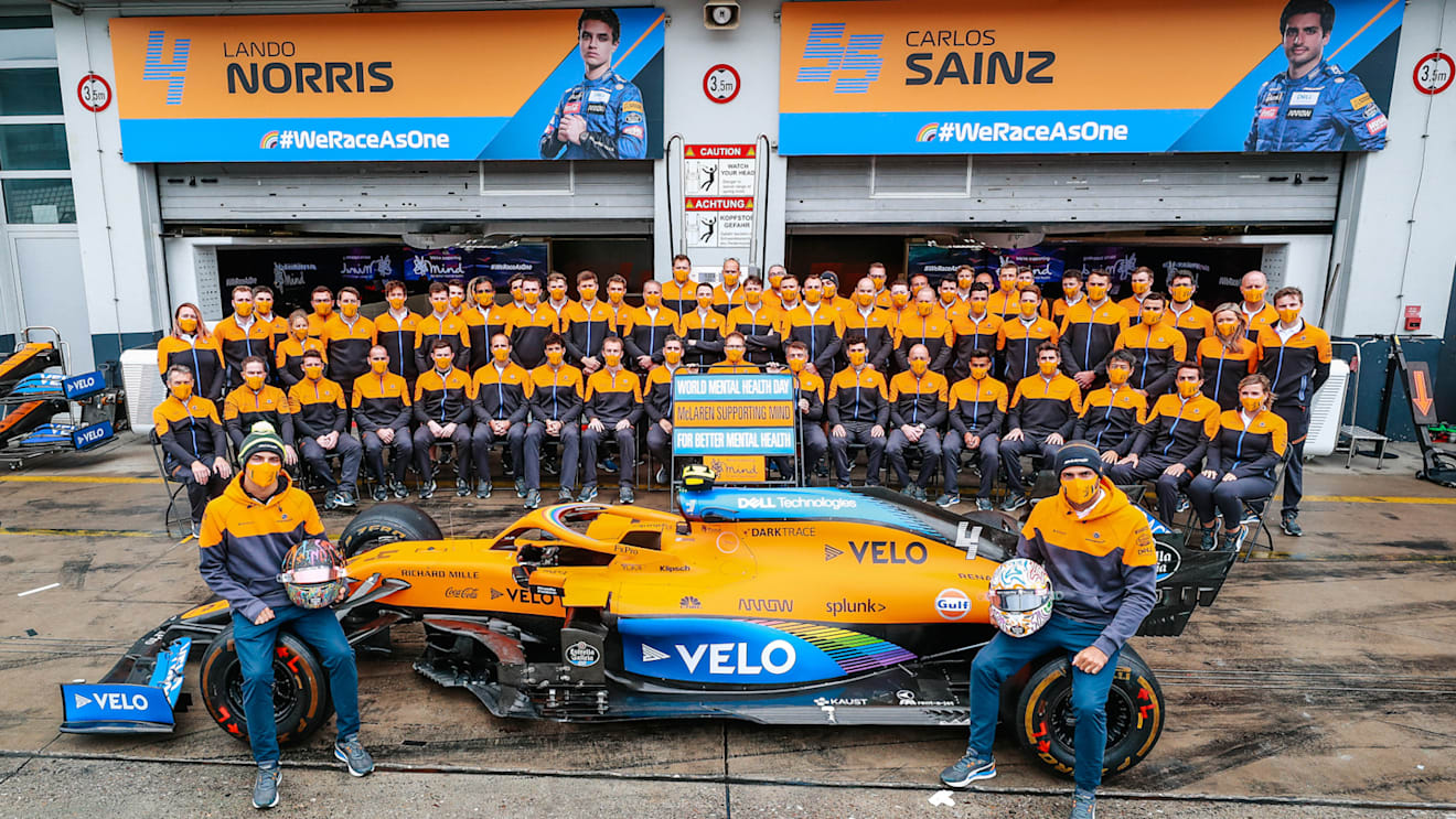 Sainz and Norris pose with the MCL35 and their team for World Mental Health Day. The team and their fans have raised nearly £200k since July for the charity Mind.