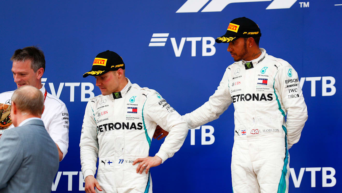 SOCHI AUTODROM, RUSSIAN FEDERATION - SEPTEMBER 30: Lewis Hamilton, Mercedes AMG F1, 1st position, consoles team mate Valtteri Bottas, Mercedes AMG F1, 2nd position, on the podium during the Russian GP at Sochi Autodrom on September 30, 2018 in Sochi Autodrom, Russian Federation. (Photo by Sam Bloxham / LAT Images)