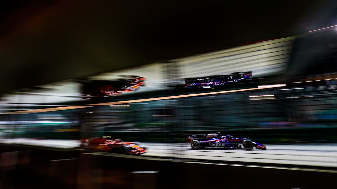 SINGAPORE STREET CIRCUIT, SINGAPORE - SEPTEMBER 14: Pierre Gasly, Scuderia Toro Rosso STR13, leads Kimi Raikkonen, Ferrari SF71H during the Singapore GP at Singapore Street Circuit on September 14, 2018 in Singapore Street Circuit, Singapore. (Photo by Zak Mauger / LAT Images)