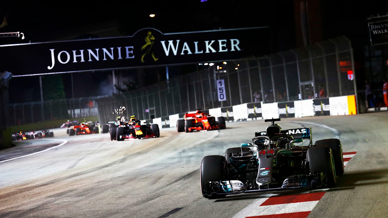 SINGAPORE STREET CIRCUIT, SINGAPORE - SEPTEMBER 16: Lewis Hamilton, Mercedes AMG F1 W09 EQ Power+, leads Max Verstappen, Red Bull Racing RB14, and Sebastian Vettel, Ferrari SF71H, at the start of the race during the Singapore GP at Singapore Street Circuit on September 16, 2018 in Singapore Street Circuit, Singapore. (Photo by Sam Bloxham / LAT Images)