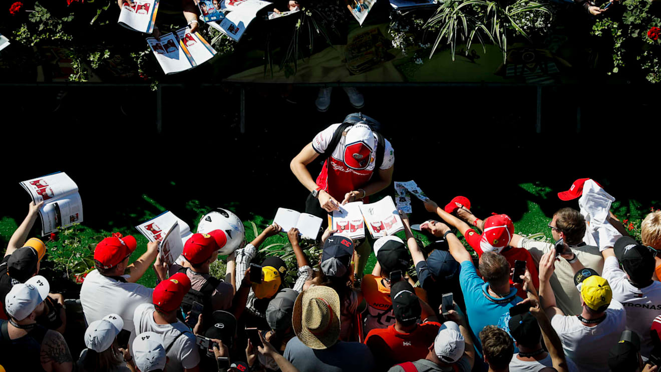RED BULL RING, AUSTRIA - JUNE 29: Antonio Giovinazzi, Alfa Romeo Racing signs a autograph for a fan during the Austrian GP at Red Bull Ring on June 29, 2019 in Red Bull Ring, Austria. (Photo by Zak Mauger / LAT Images)