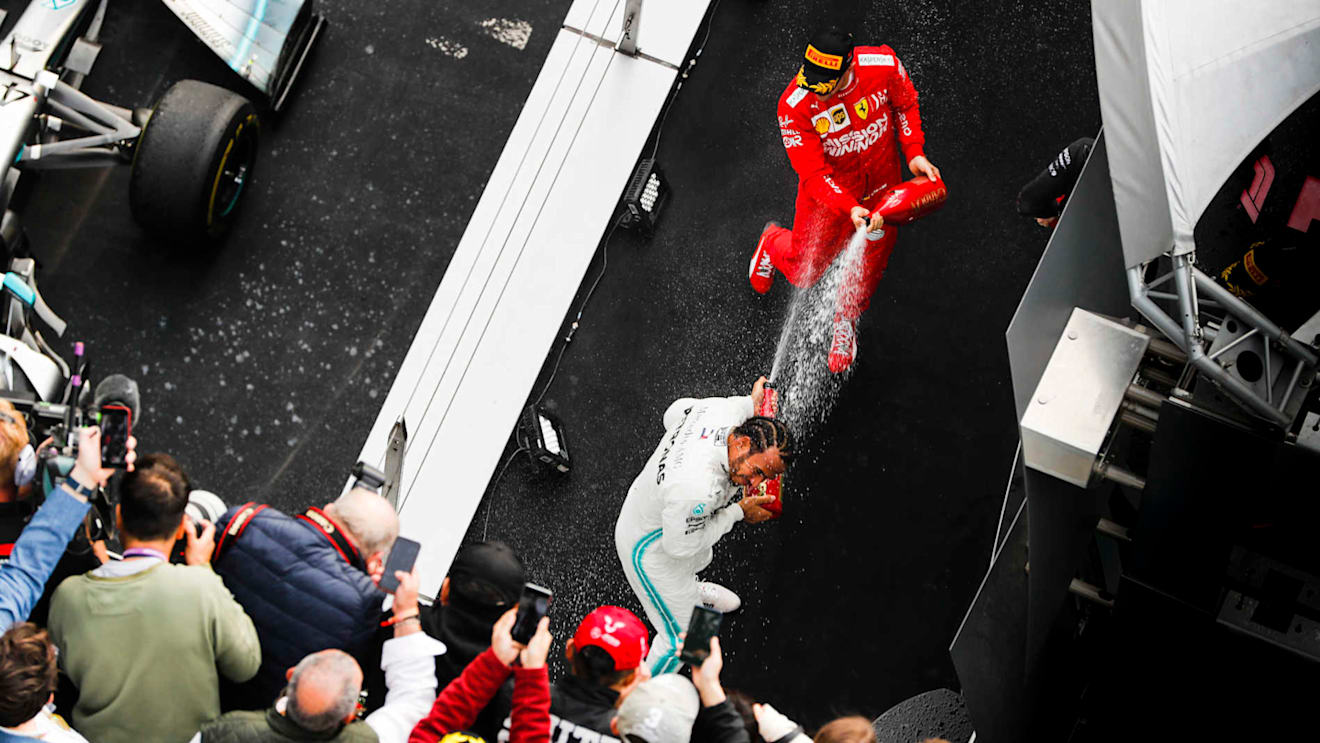 SHANGHAI INTERNATIONAL CIRCUIT, CHINA - APRIL 14: Lewis Hamilton, Mercedes AMG F1, 1st position, and Sebastian Vettel, Ferrari, 3rd position, spray Champagne on the podium during the Chinese GP at Shanghai International Circuit on April 14, 2019 in Shanghai International Circuit, China. (Photo by Steven Tee / LAT Images)