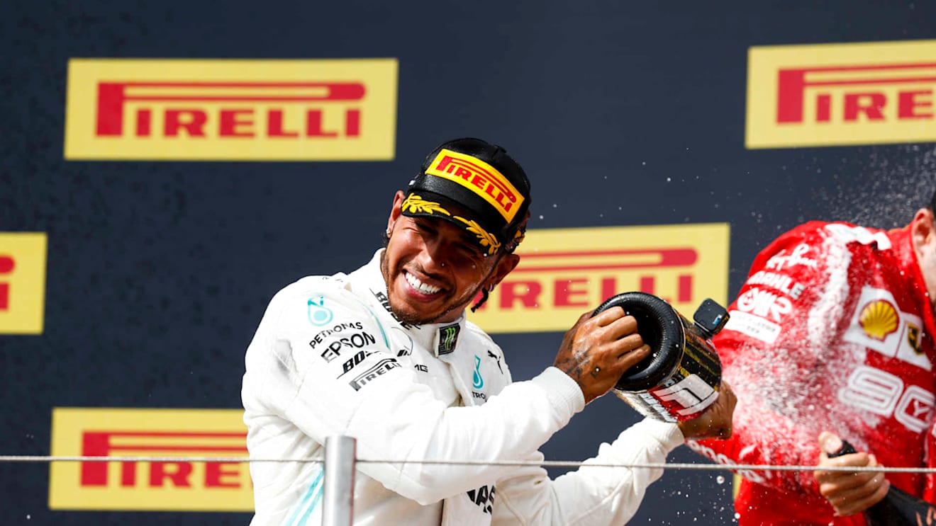 CIRCUIT PAUL RICARD, FRANCE - JUNE 23: Lewis Hamilton, Mercedes AMG F1, 1st position, and Charles Leclerc, Ferrari, 3rd position, spray Champagne on the podium during the French GP at Circuit Paul Ricard on June 23, 2019 in Circuit Paul Ricard, France. (Photo by Joe Portlock / LAT Images)