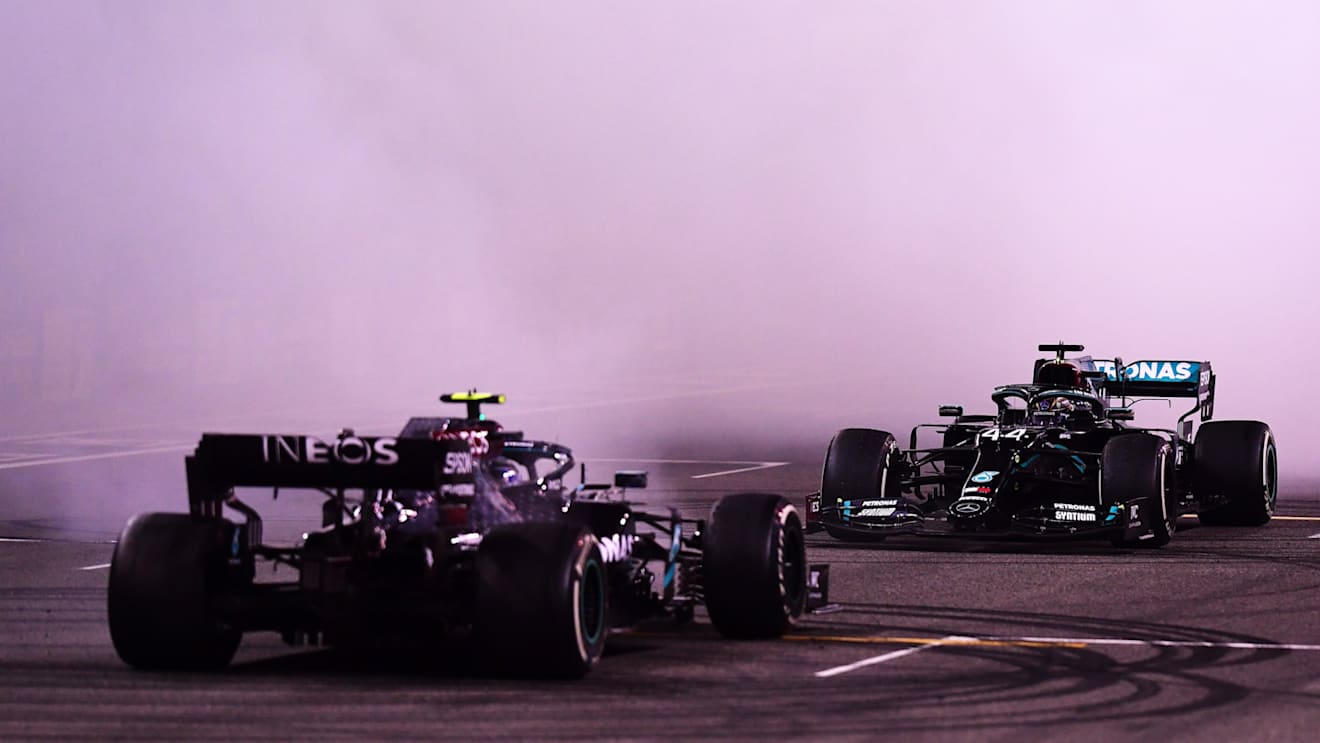 ABU DHABI, UNITED ARAB EMIRATES - DECEMBER 13: Second placed Valtteri Bottas of Finland and Mercedes GP and third placed Lewis Hamilton of Great Britain and Mercedes GP perform donuts following the F1 Grand Prix of Abu Dhabi at Yas Marina Circuit on December 13, 2020 in Abu Dhabi, United Arab Emirates. (Photo by Mario Renzi - Formula 1/Formula 1 via Getty Images)
