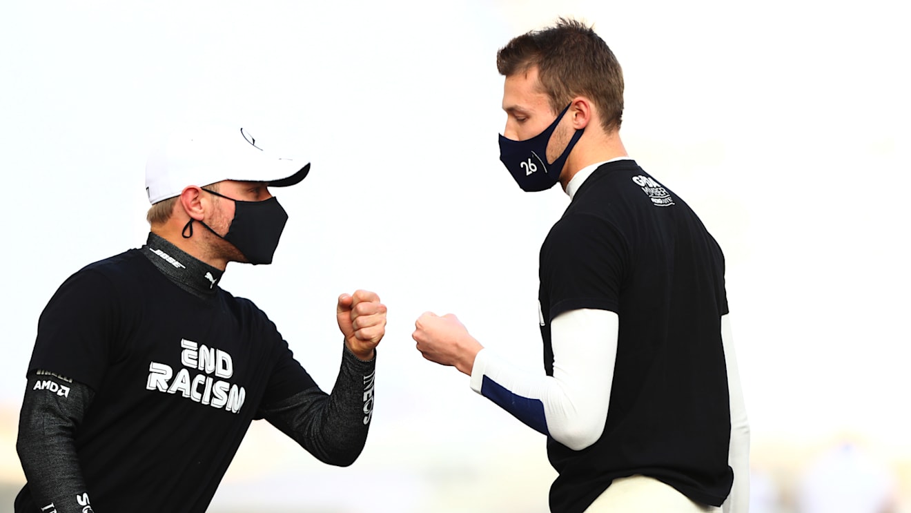 ABU DHABI, UNITED ARAB EMIRATES - DECEMBER 13: Valtteri Bottas of Finland and Mercedes GP and Daniil Kvyat of Russia and Scuderia AlphaTauri fist bump as they stand on the grid prior to the F1 Grand Prix of Abu Dhabi at Yas Marina Circuit on December 13, 2020 in Abu Dhabi, United Arab Emirates. (Photo by Dan Istitene - Formula 1/Formula 1 via Getty Images)
