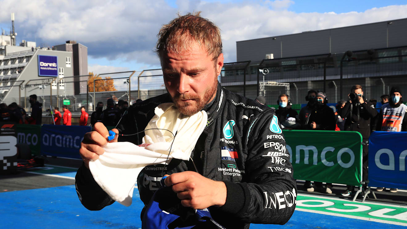NUERBURG, GERMANY - OCTOBER 10: Pole position qualifier Valtteri Bottas of Finland and Mercedes GP removes his balaclava in parc ferme during qualifying ahead of the F1 Eifel Grand Prix at Nuerburgring on October 10, 2020 in Nuerburg, Germany. (Photo by Wolfgang Rattay - Pool/Getty Images)