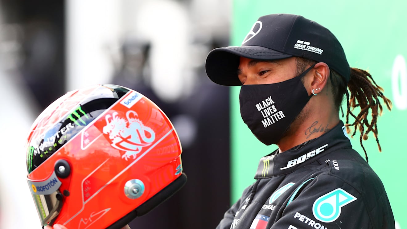 NUERBURG, GERMANY - OCTOBER 11: Race winner Lewis Hamilton of Great Britain and Mercedes GP celebrates after being presented with a helmet of Michael Schumacher for matching his record of 91 race wins during the F1 Eifel Grand Prix at Nuerburgring on October 11, 2020 in Nuerburg, Germany. (Photo by Dan Istitene - Formula 1/Formula 1 via Getty Images)