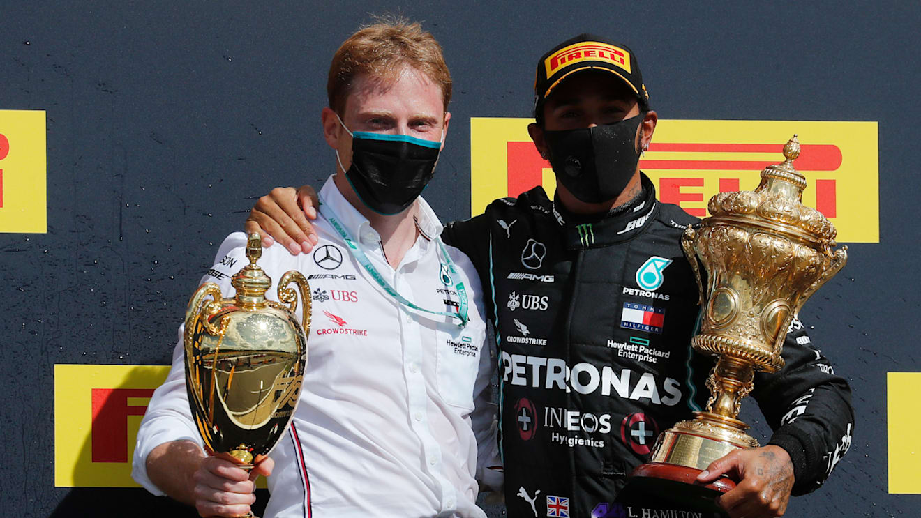 NORTHAMPTON, ENGLAND - AUGUST 02: Race winner Lewis Hamilton of Great Britain and Mercedes GP celebrates with a team member on the podium during the F1 Grand Prix of Great Britain at Silverstone on August 02, 2020 in Northampton, England. (Photo by Frank Augstein/Pool via Getty Images)
