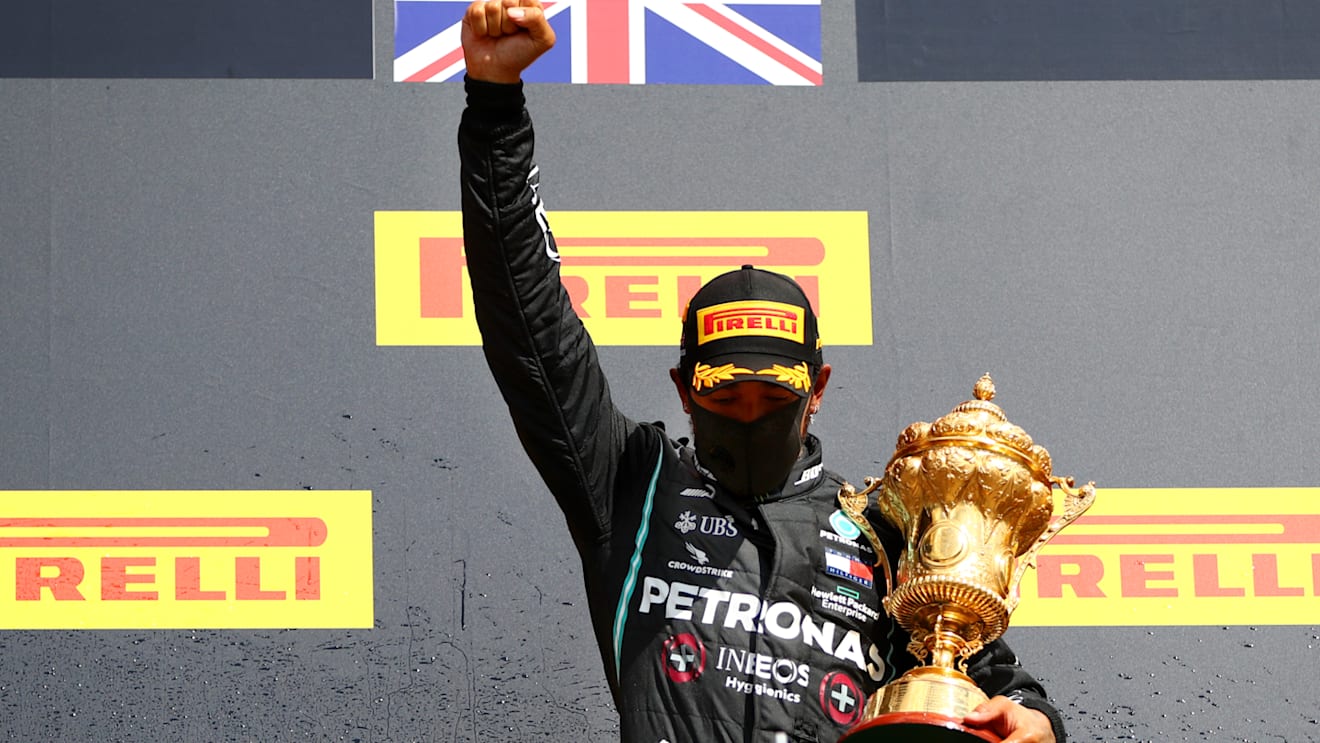 NORTHAMPTON, ENGLAND - AUGUST 02: Lewis Hamilton of Great Britain and Mercedes GP raises his fist as he celebrates on the podium after winning the Formula One Grand Prix of Hungary at Silverstone on August 02, 2020 in Northampton, England. (Photo by Dan Istitene - Formula 1/Formula 1 via Getty Images)