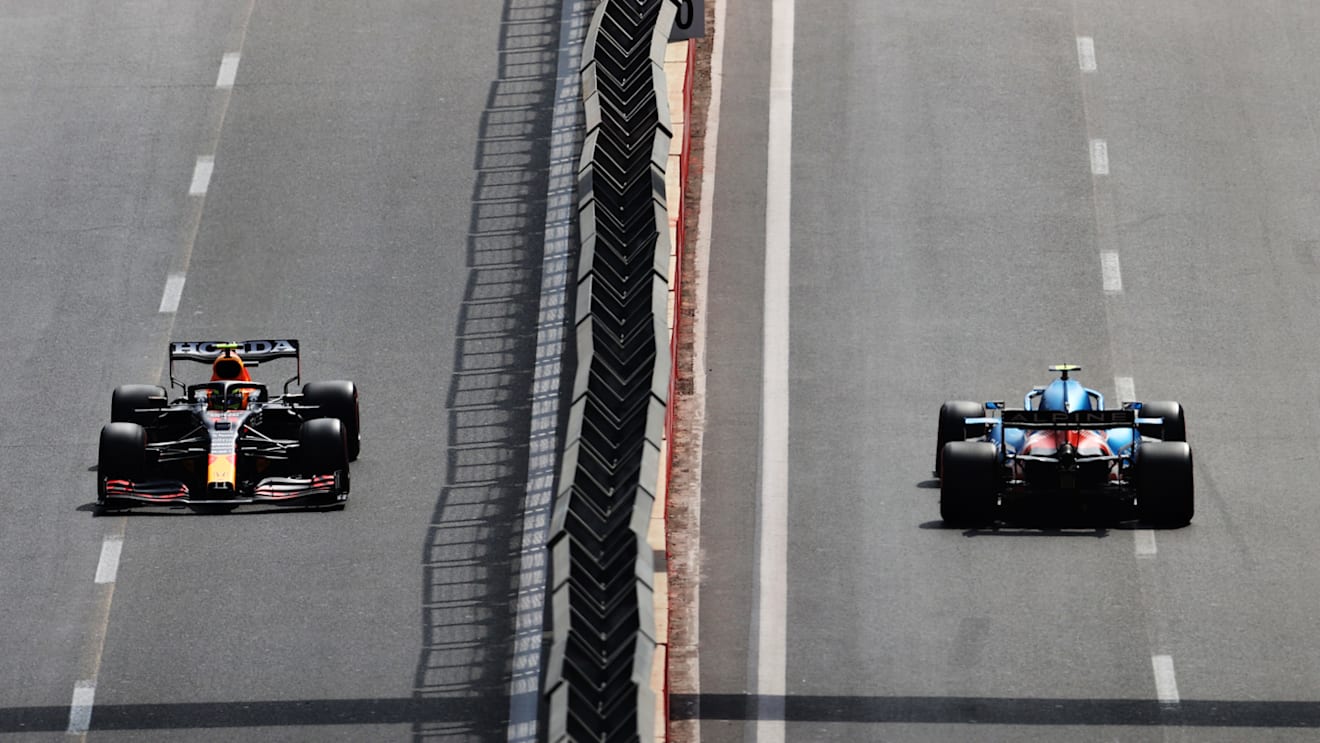 BAKU, AZERBAIJAN - JUNE 06: Sergio Perez of Mexico driving the (11) Red Bull Racing RB16B Honda and Esteban Ocon of France driving the (31) Alpine A521 Renault on their way to the grid before the F1 Grand Prix of Azerbaijan at Baku City Circuit on June 06, 2021 in Baku, Azerbaijan. (Photo by Clive Rose/Getty Images)