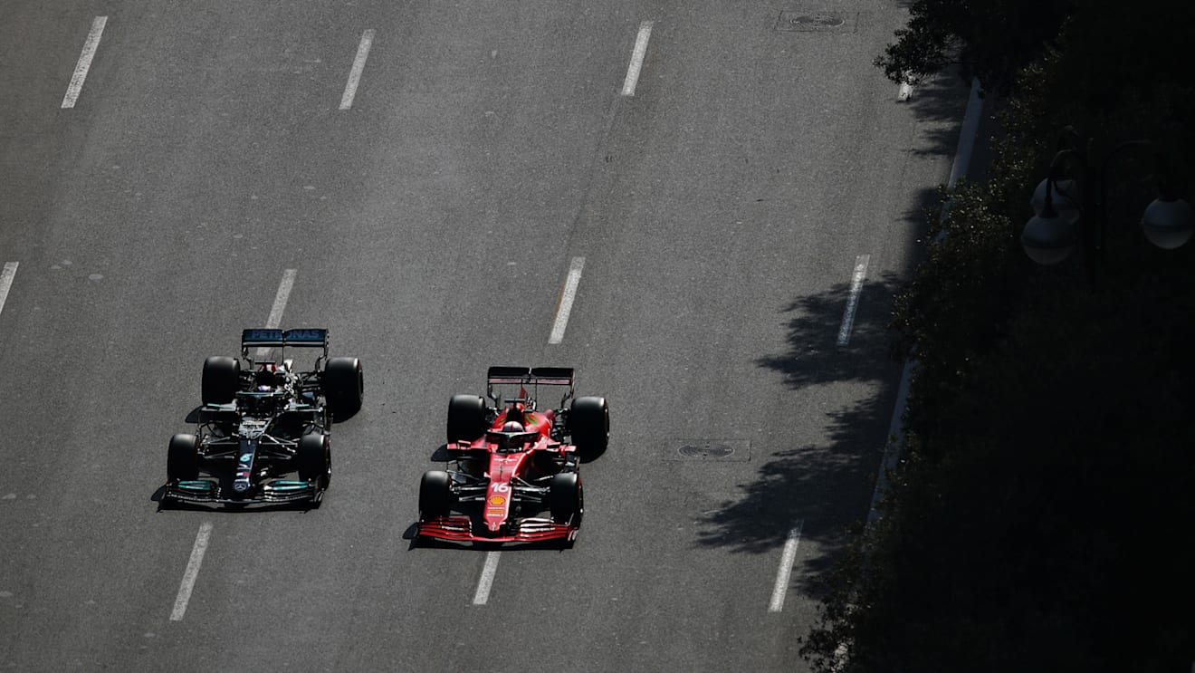 BAKU, AZERBAIJAN - JUNE 06: Lewis Hamilton of Great Britain driving the (44) Mercedes AMG Petronas F1 Team Mercedes W12 and Charles Leclerc of Monaco driving the (16) Scuderia Ferrari SF21 battle for track position during the F1 Grand Prix of Azerbaijan at Baku City Circuit on June 06, 2021 in Baku, Azerbaijan. (Photo by Joe Portlock - Formula 1/Formula 1 via Getty Images)