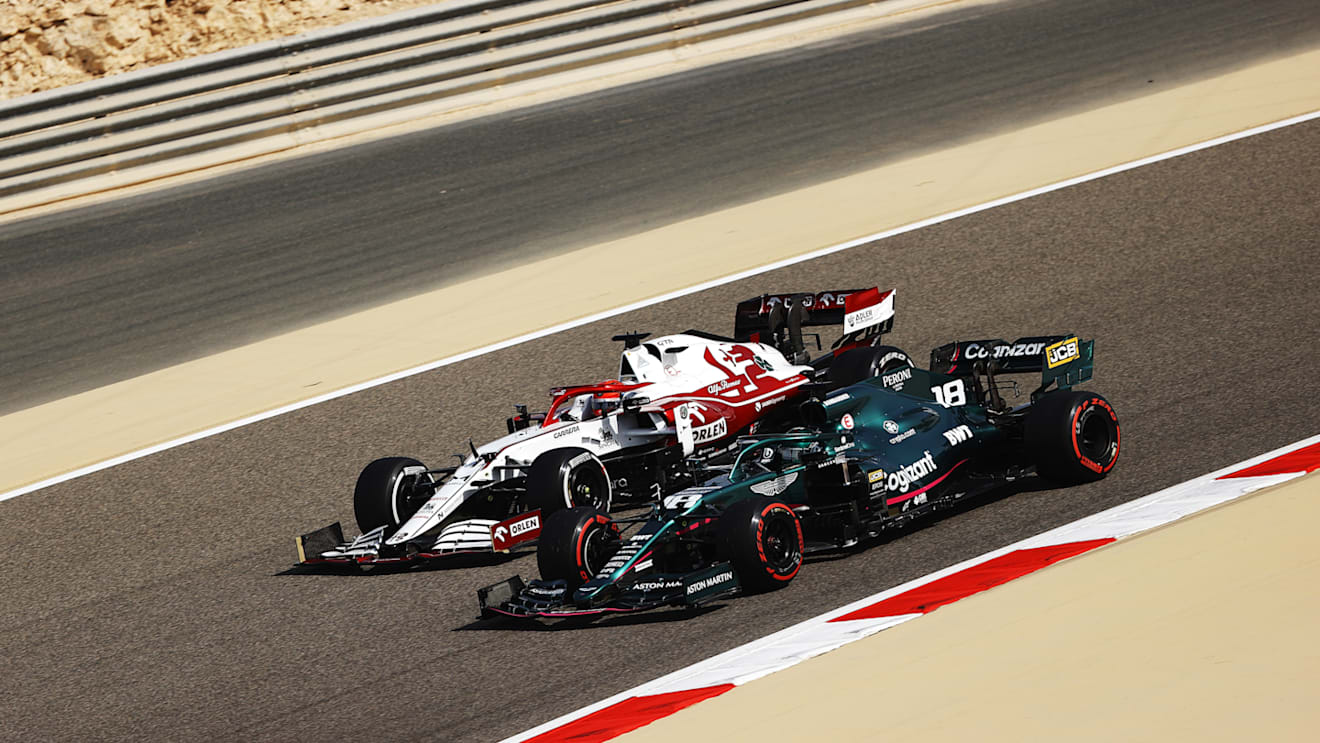 BAHRAIN, BAHRAIN - MARCH 26: Kimi Raikkonen of Finland driving the (7) Alfa Romeo Racing C41 Ferrari and Lance Stroll of Canada driving the (18) Aston Martin AMR21 Mercedes drive on track during practice ahead of the F1 Grand Prix of Bahrain at Bahrain International Circuit on March 26, 2021 in Bahrain, Bahrain. (Photo by Bryn Lennon/Getty Images)