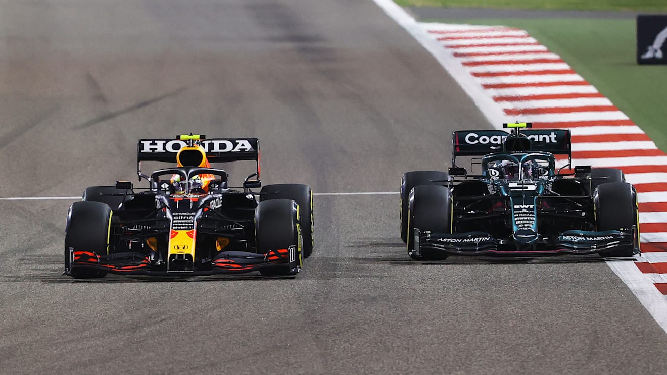 BAHRAIN, BAHRAIN - MARCH 28: Sergio Perez of Mexico driving the (11) Red Bull Racing RB16B Honda and Sebastian Vettel of Germany driving the (5) Aston Martin AMR21 Mercedes compete for position on track during the F1 Grand Prix of Bahrain at Bahrain International Circuit on March 28, 2021 in Bahrain, Bahrain. (Photo by Bryn Lennon/Getty Images)