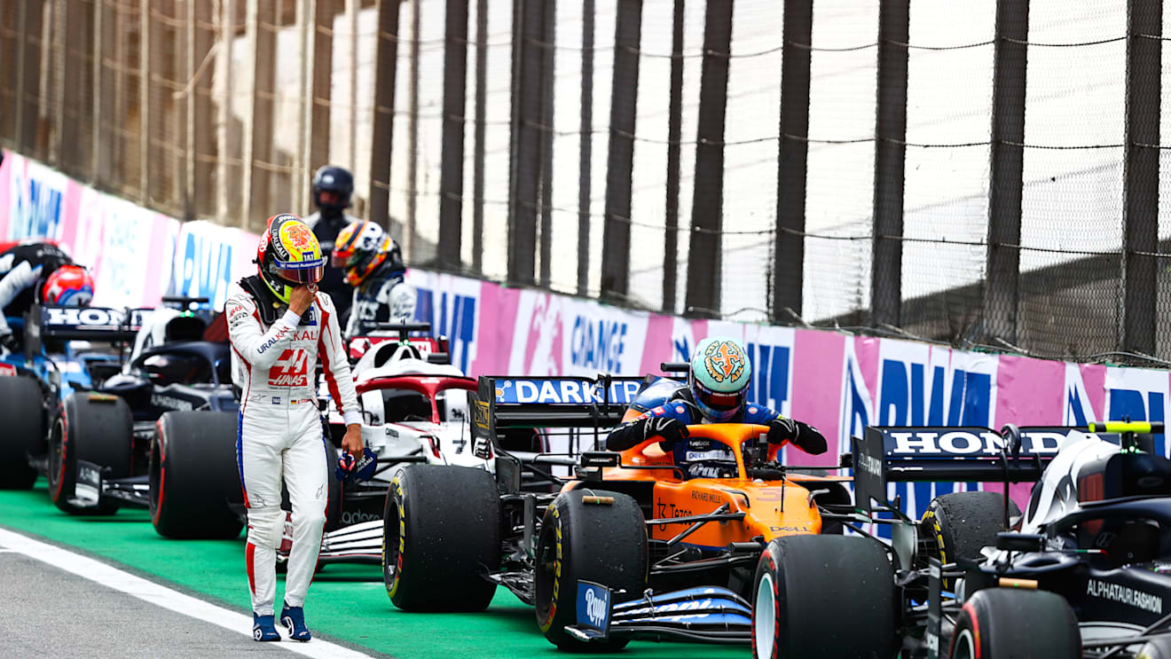 SAO PAULO, BRAZIL - NOVEMBER 13: Mick Schumacher of Germany and Haas F1 walks past Daniel Ricciardo of Australia and McLaren F1 in parc ferme during the sprint ahead of the F1 Grand Prix of Brazil at Autodromo Jose Carlos Pace on November 13, 2021 in Sao Paulo, Brazil. (Photo by Mark Thompson/Getty Images)